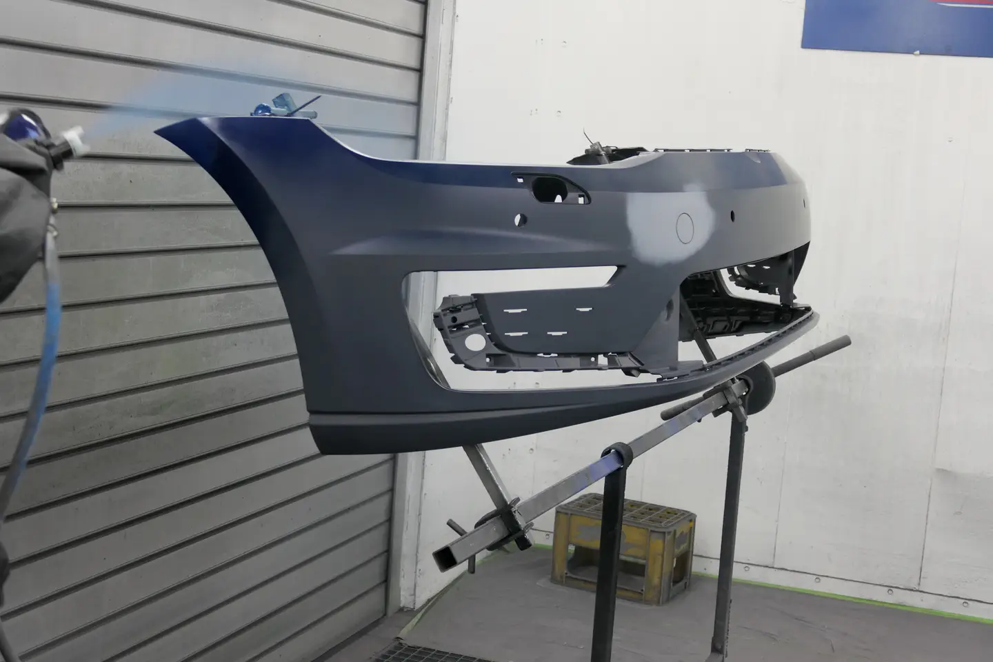 Impressionen demontierte Stoßstange auf einem Ständer,
zum Lackieren in der Lackierkabine
